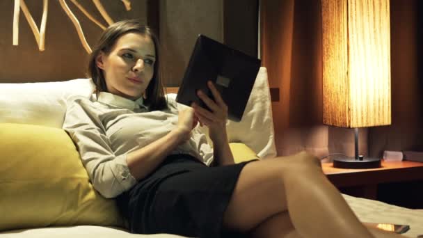 Businesswoman using tablet computer on bed — Stock Video