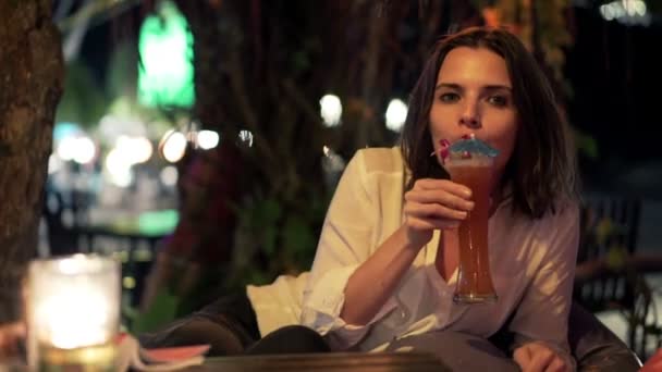 Женщина поднимает тост за камеру и пьет коктейль — стоковое видео