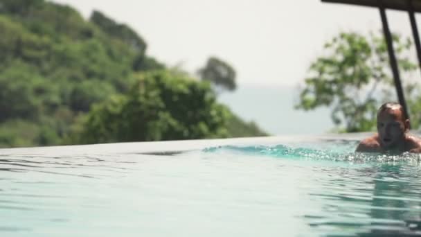 Hombre joven nadando en la piscina — Vídeos de Stock