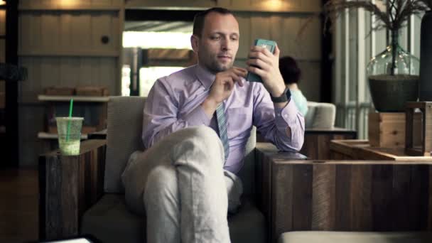 Businessman using smartphone while sitting in cafe — Stock Video