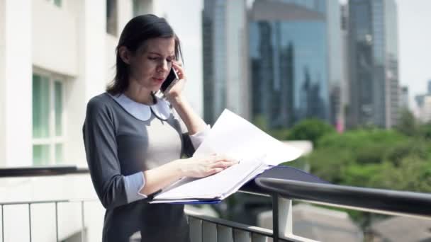 Femme d'affaires avec des documents parlant sur téléphone portable — Video