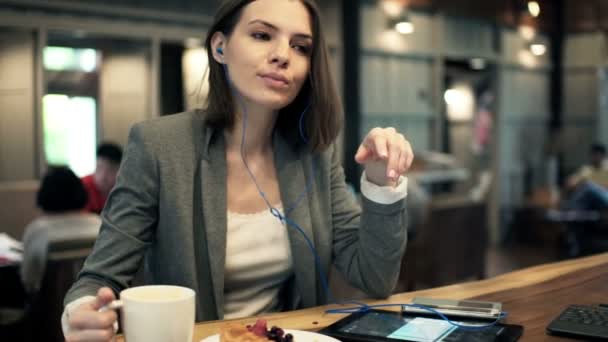 Geschäftsfrau hört Musik auf dem Handy und trinkt Kaffee — Stockvideo