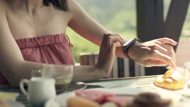 Mulher usando smartwatch durante o café da manhã — Vídeo de Stock