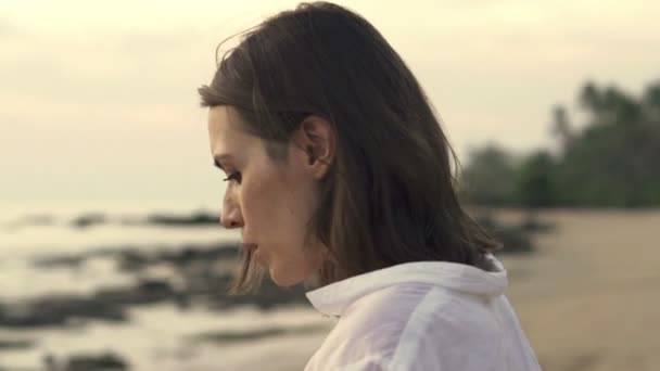 Ongelukkig, triest vrouw met de bloem op het strand — Stockvideo