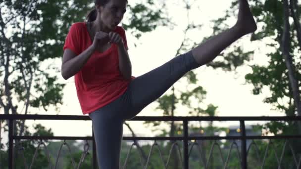 Женщина упражняется, пинается на крыльце — стоковое видео