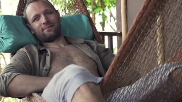 Homem feliz relaxando na rede no terraço — Vídeo de Stock