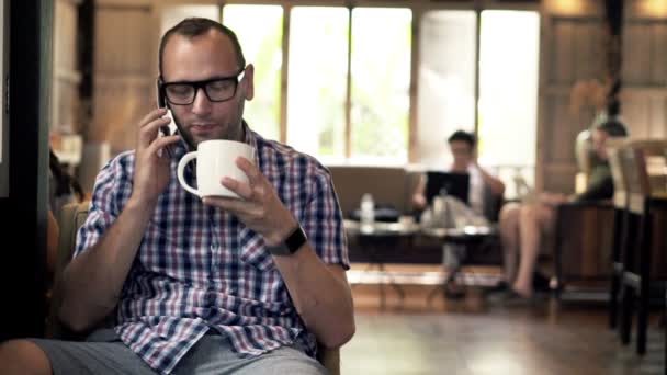 Man talking on cellphone and drinking coffee — Stock Video