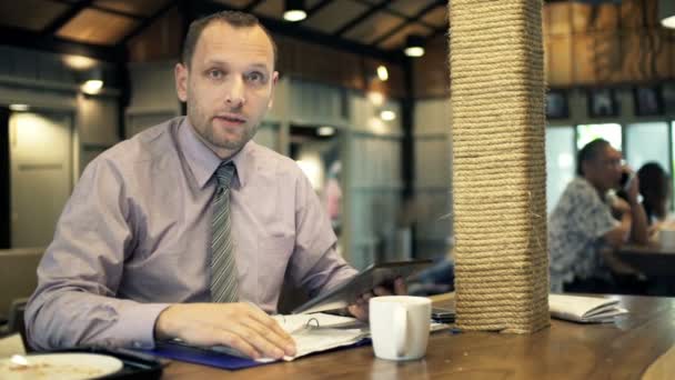 Homme d'affaires avec tablette et documents parlant — Video