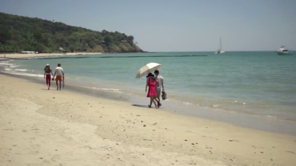 Personas con sombrillas caminando en la playa en Tailandia — Vídeos de Stock