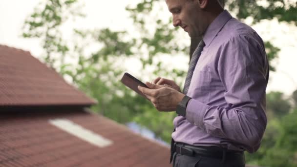 Biznesmen przy użyciu komputera typu tablet na tarasie — Wideo stockowe