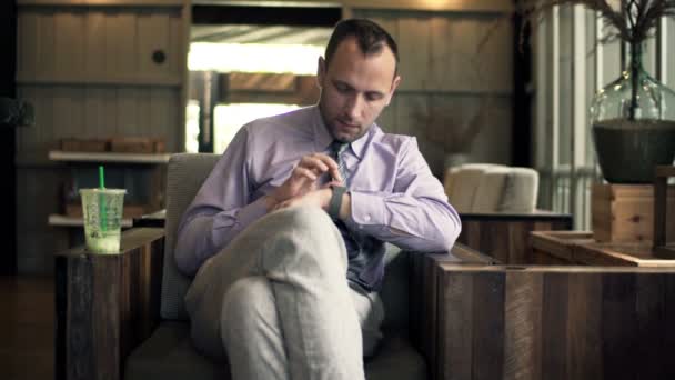 Affärsman med smartwatch sitter i café — Stockvideo