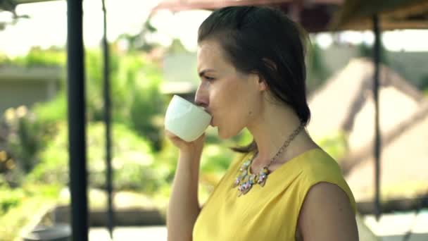 Pensive woman drinking coffee on terrace — Stock Video