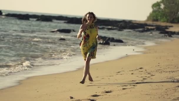 Mujer feliz corriendo en la playa — Vídeo de stock