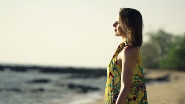 Vrouw ontspannen op het strand tijdens zonsondergang — Stockvideo