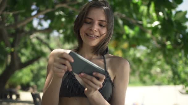 Mujer jugando en el teléfono inteligente en el parque — Vídeos de Stock