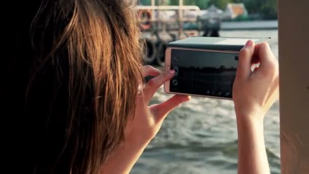 Mulher filmando vídeo com smartphone enquanto monta barco — Vídeo de Stock