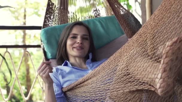 Kvinnan talar med kameran ligger på hammock — Stockvideo