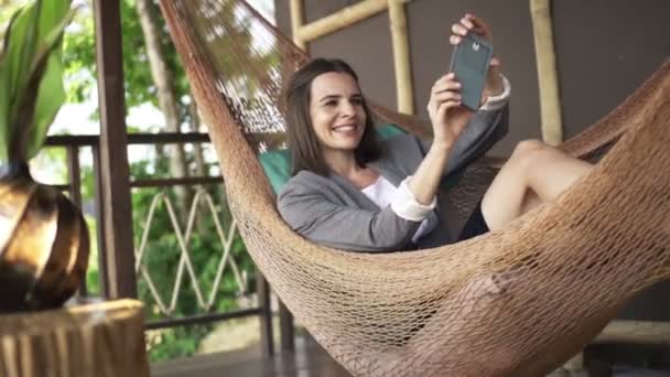 Mujer de negocios tomando foto selfie con teléfono inteligente en hamaca — Vídeos de Stock