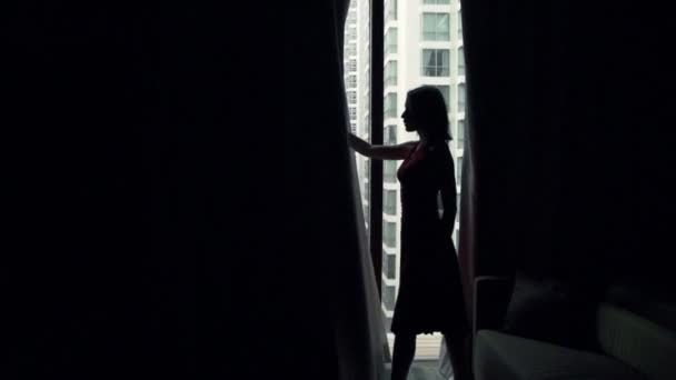 Woman unveil curtains and stretching arms by window — Stock Video