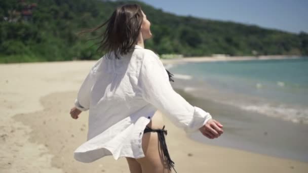 Mujer feliz dando la vuelta en la playa — Vídeos de Stock