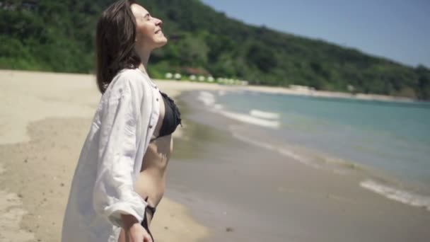 Щаслива жінка розтягує руки на пляжі — стокове відео