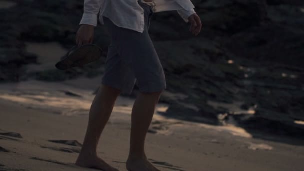 Hombre caminando en la playa al atardecer — Vídeos de Stock