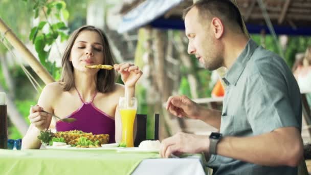 Пара разговаривает и едят еду в кафе — стоковое видео
