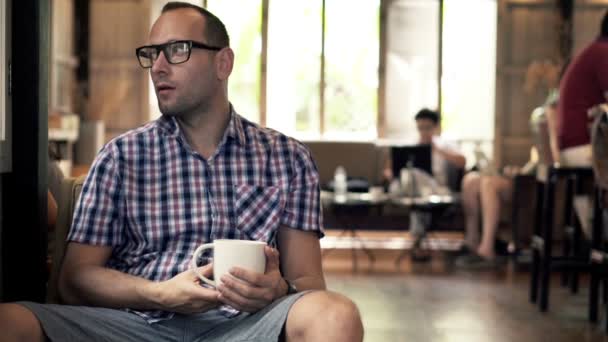 Man dricka kaffe när man sitter i café — Stockvideo