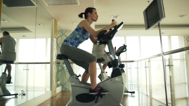 İnsanlar binme sabit Bisiklet spor salonunda — Stok video