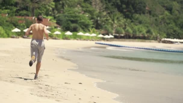 Homem correndo em bela praia — Vídeo de Stock