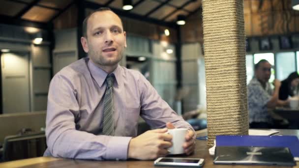 Happy businessman drinking coffee in cafe — Stock Video