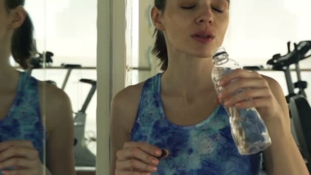 女人喝水后在健身房锻炼 — 图库视频影像