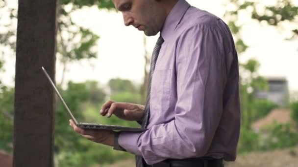 Ung affärsman arbetar med laptop på terrassen — Stockvideo