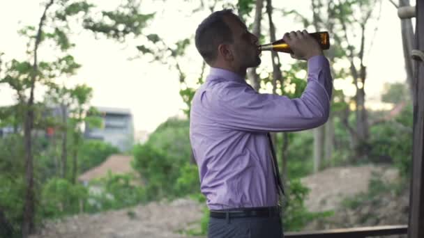 Jungunternehmer trinkt Bier auf Terrasse — Stockvideo