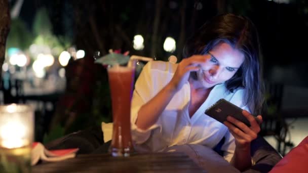 Mujer viendo la película en el teléfono inteligente y bebida — Vídeos de Stock