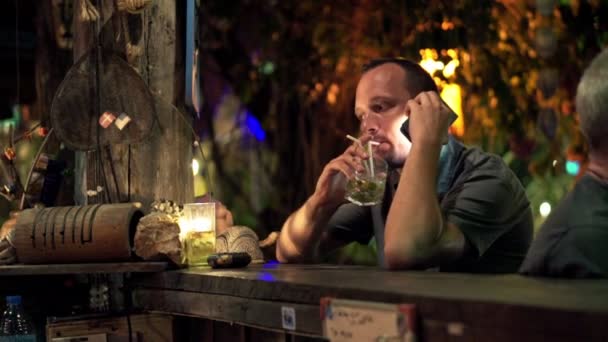 Hombre hablando por celular y bebiendo bebidas — Vídeos de Stock