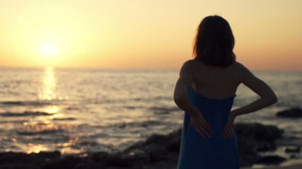 Mulher admirar pôr do sol enquanto está de pé na praia — Vídeo de Stock