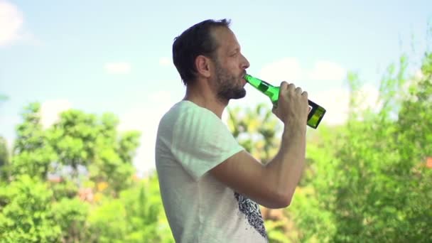 Hombre feliz bebiendo cerveza en el jardín — Vídeos de Stock