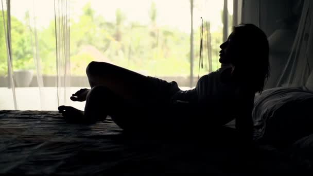 Frau wacht auf und streckt Arme auf dem Bett aus — Stockvideo