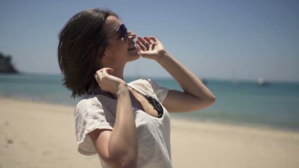 Mujer feliz jugando con el pelo en la playa — Vídeos de Stock