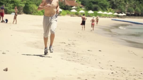 Hombre corriendo en hermosa playa — Vídeos de Stock