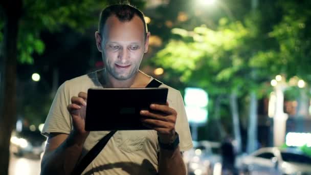 Hombre con Tablet PC en la ciudad por la noche — Vídeo de stock