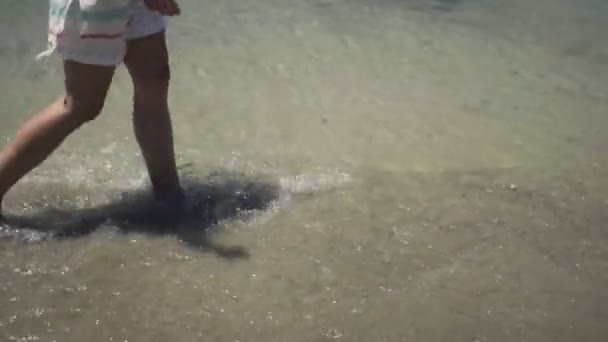 Vrouw die op het strand loopt — Stockvideo