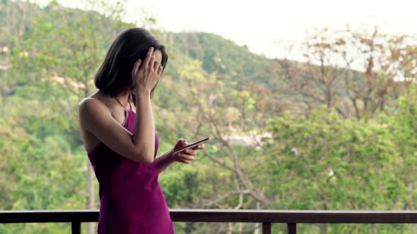 Frau steht mit Smartphone auf Terrasse — Stockvideo