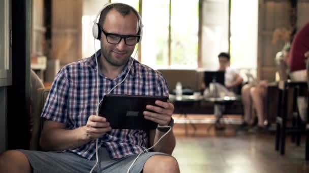 Man watching movie on tablet computer in cafe — Stock Video