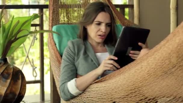 Empresaria con la computadora de la tableta que habla malas noticias en la hamaca — Vídeo de stock