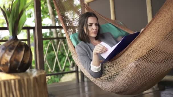 Donna d'affari che legge i documenti che si trovano sul hammock — Video Stock
