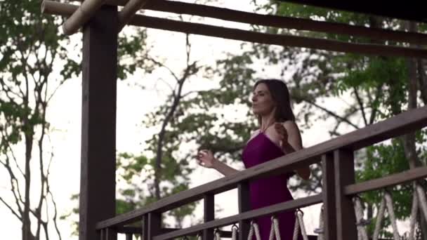 Женщина вытягивает руки на террасе — стоковое видео