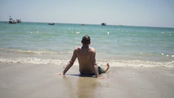 Młody człowiek wypoczynku i opalania na plaży — Wideo stockowe