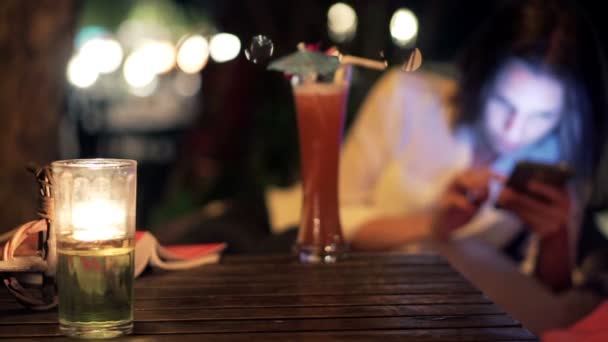 Kvinnan dricka cocktail och använder smartphone — Stockvideo